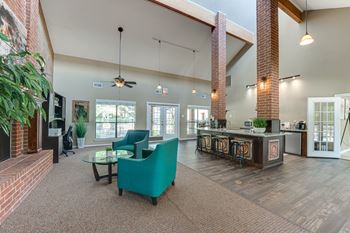 A living room with a green chair and a bar area.